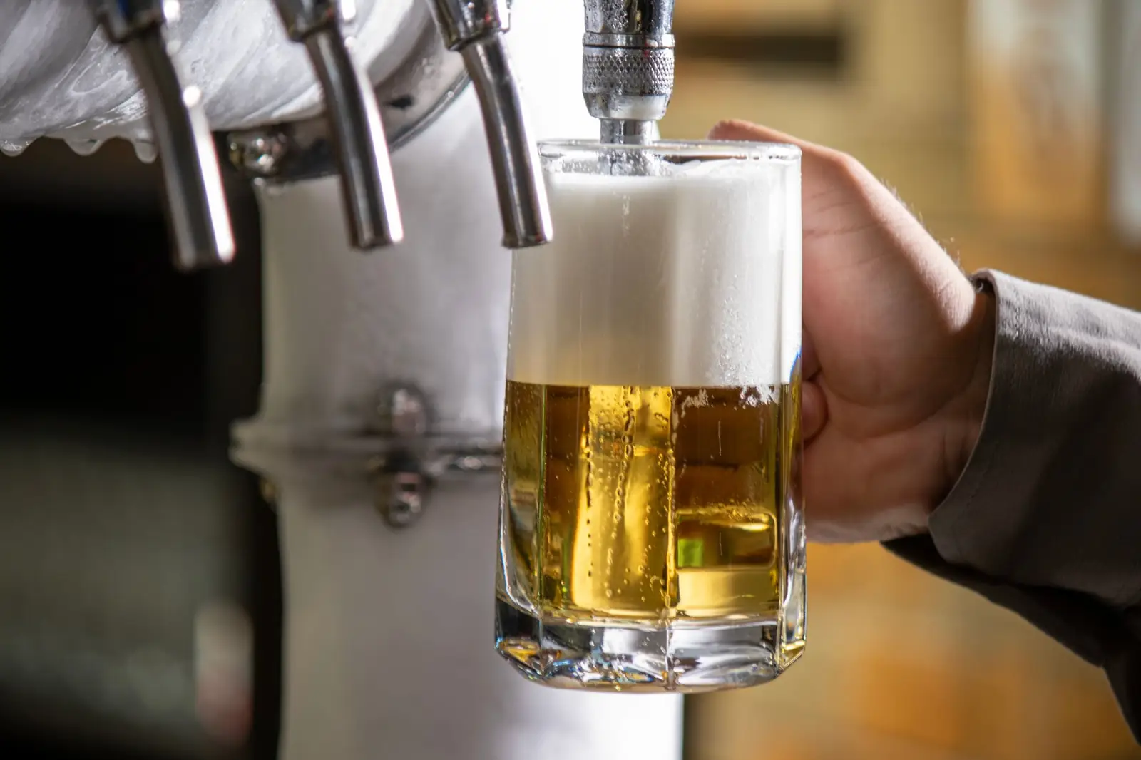 Caña de cerveza recién tirada en el grifo de un bar